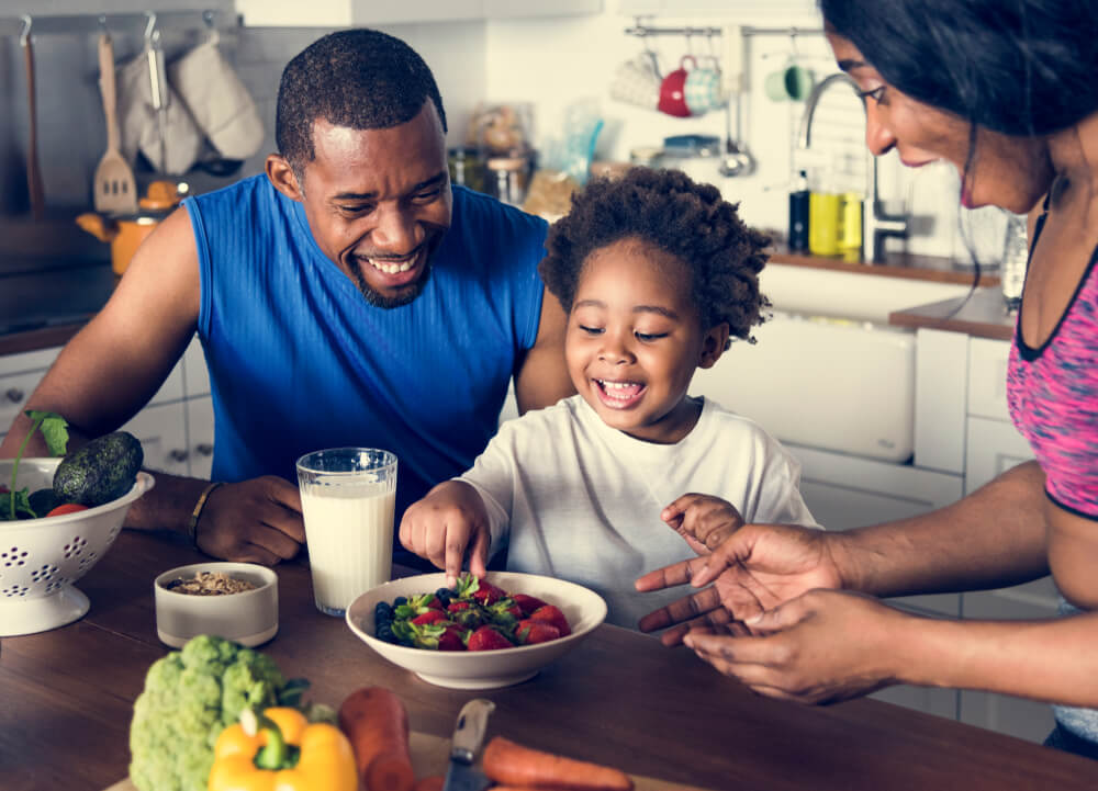 Parents smiling as child eats