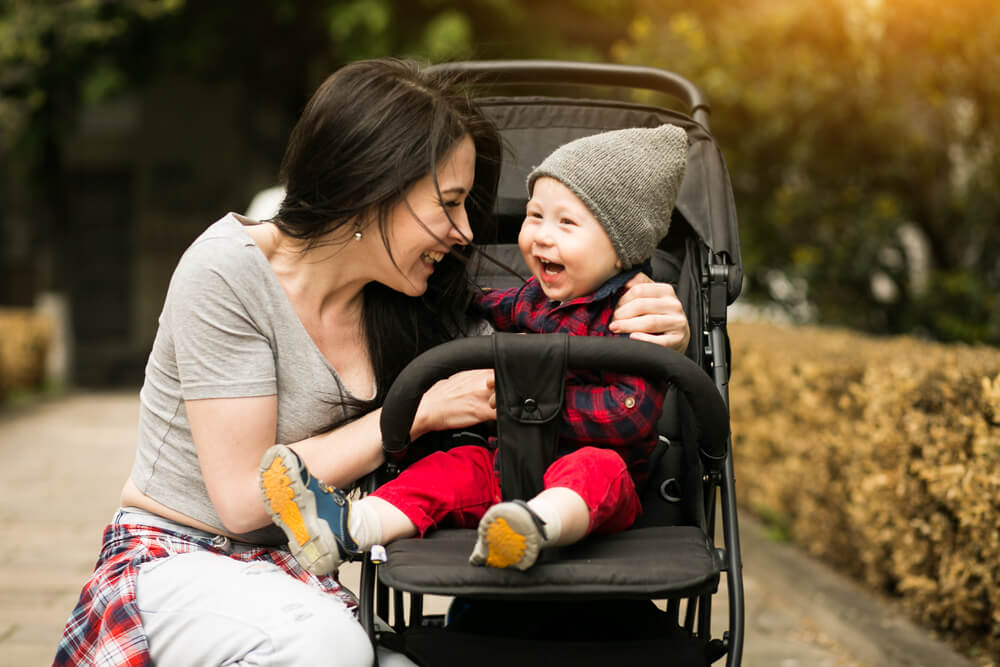 Mother Laughing with baby in stroller