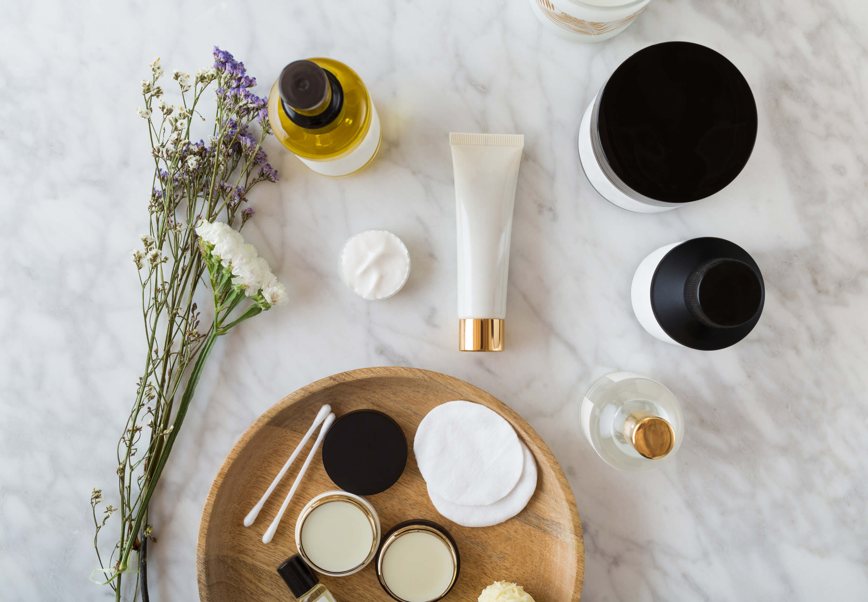Beauty Product Flatlay on White Marble Table