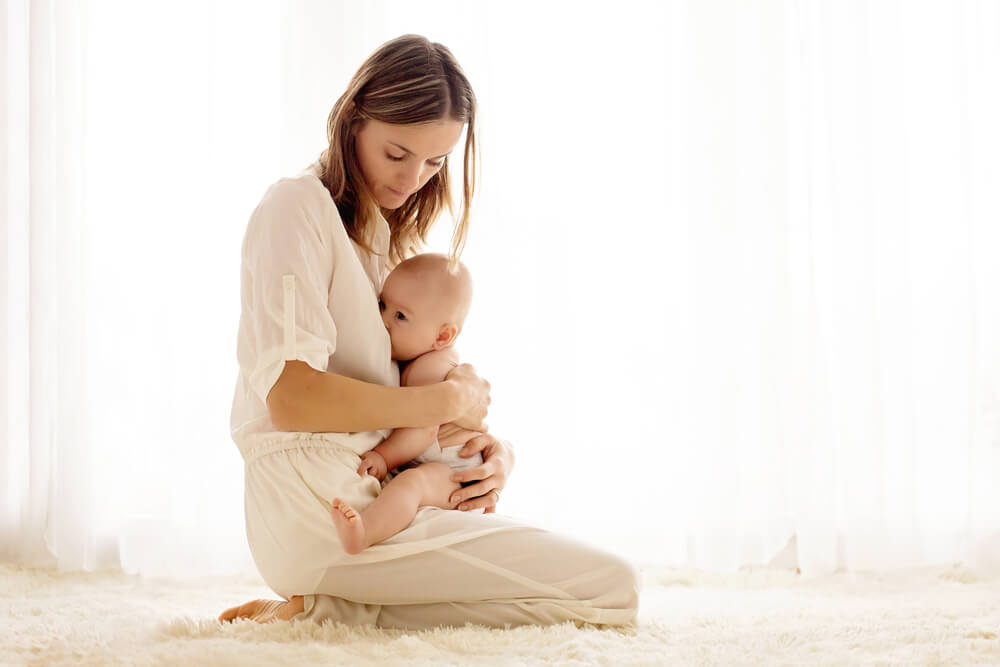 Young mother breastfeeding her newborn baby boy