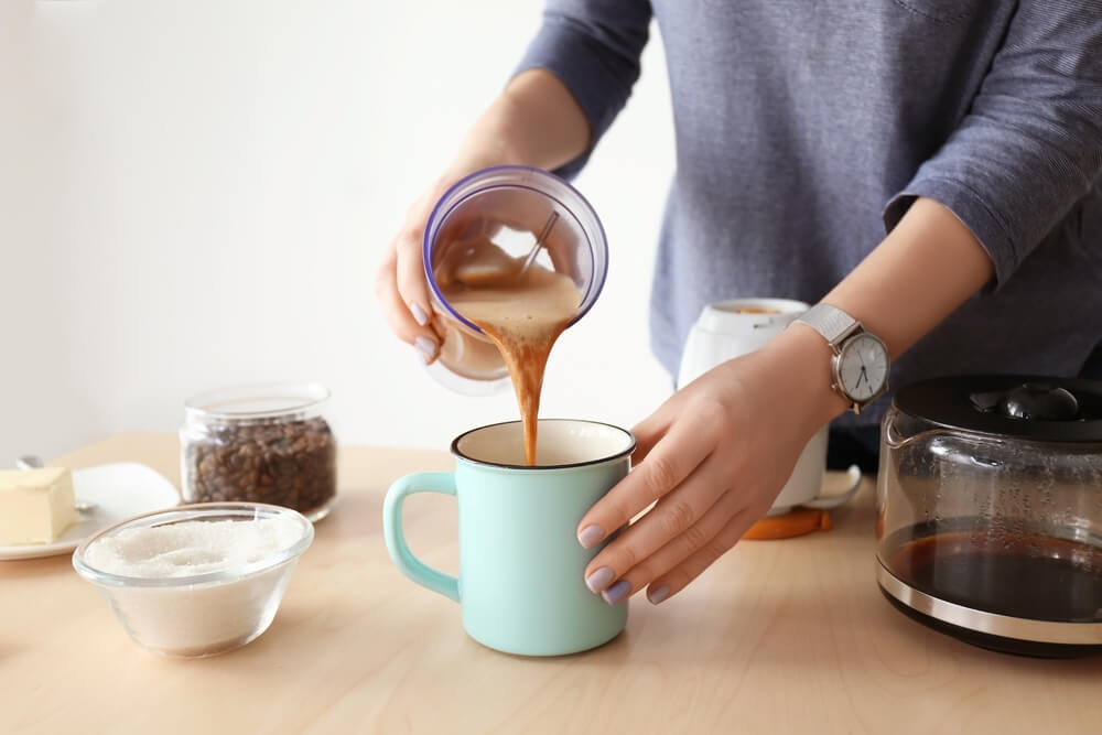 Image of someone pouring bulletproof coffee into a mug
