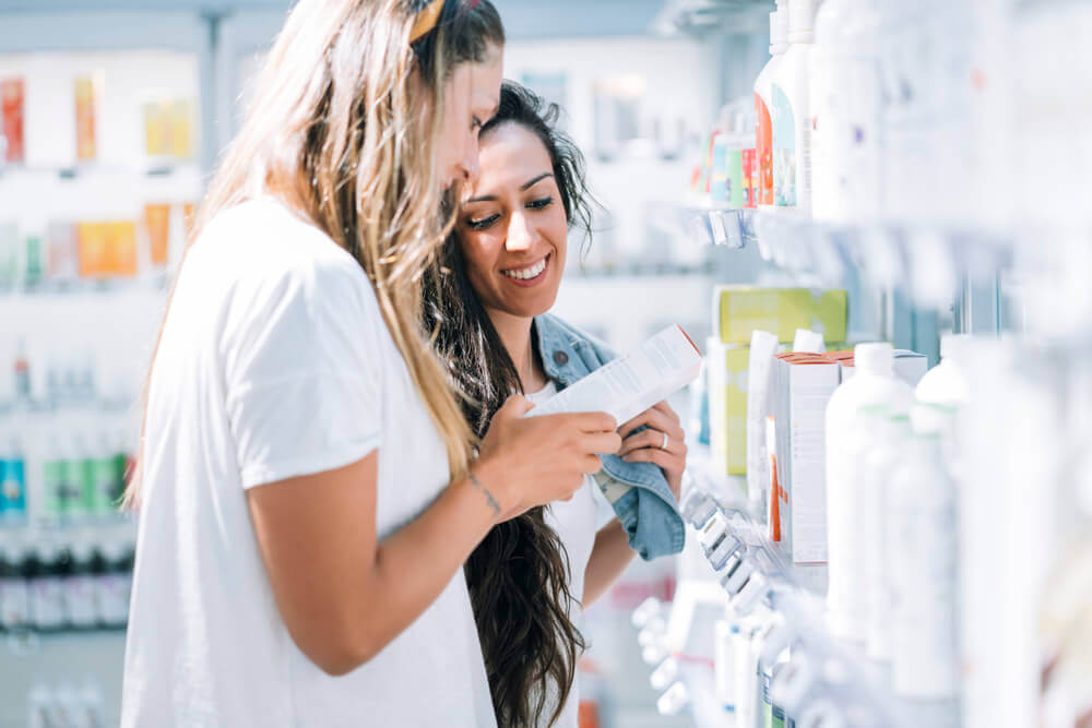 Image of two girls looking at sunscreen products in a store.