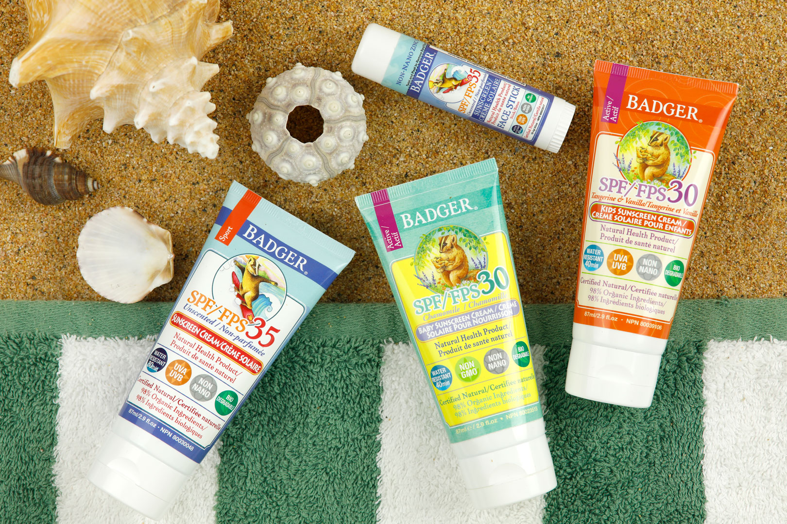 Four suncreen products on a green and brown background