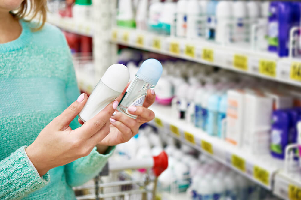 Woman comparing deodorants in a store