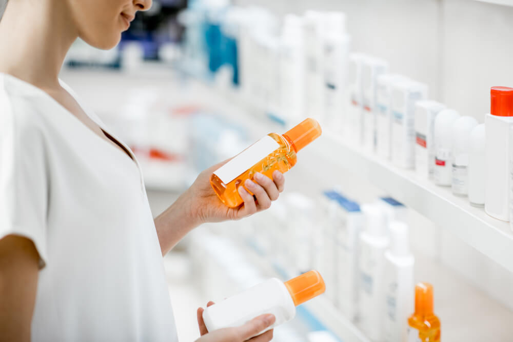 Person picking a sunscreen from a drug store aisle