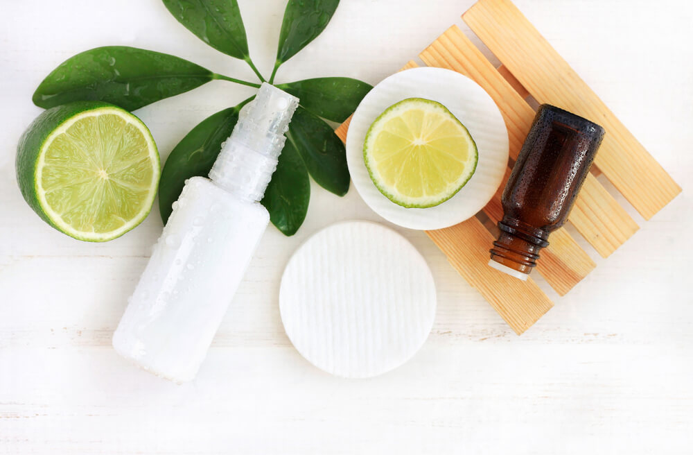 Flat lay of skincare bottles and fresh lime