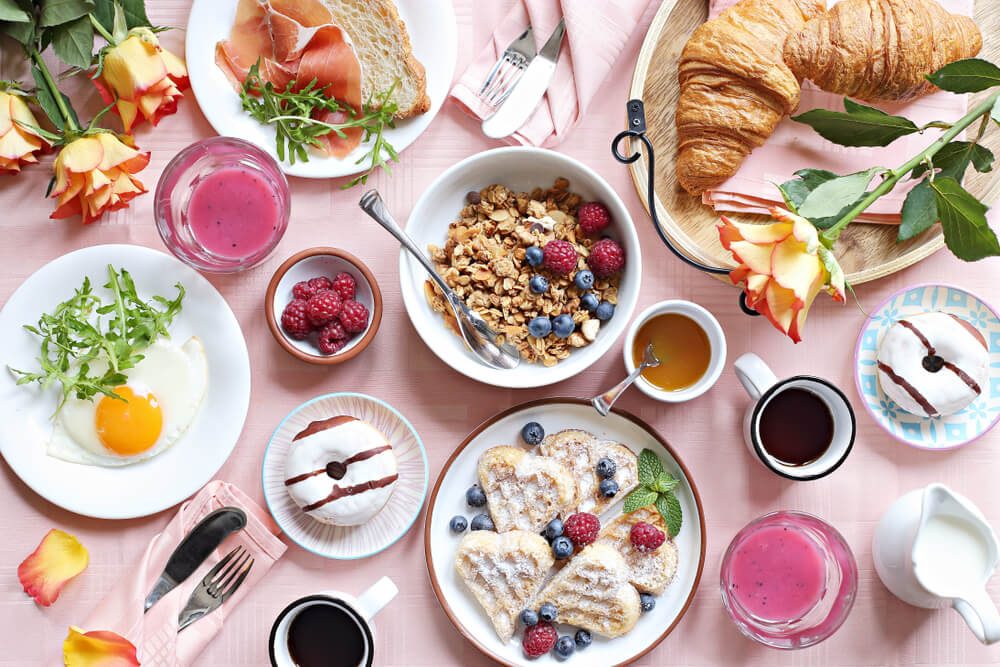 Flat lay of brunch items on a light pink background