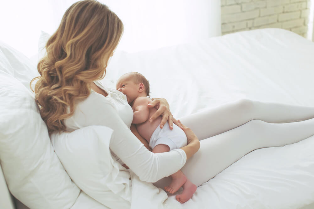 Mother Breastfeeding on a bed