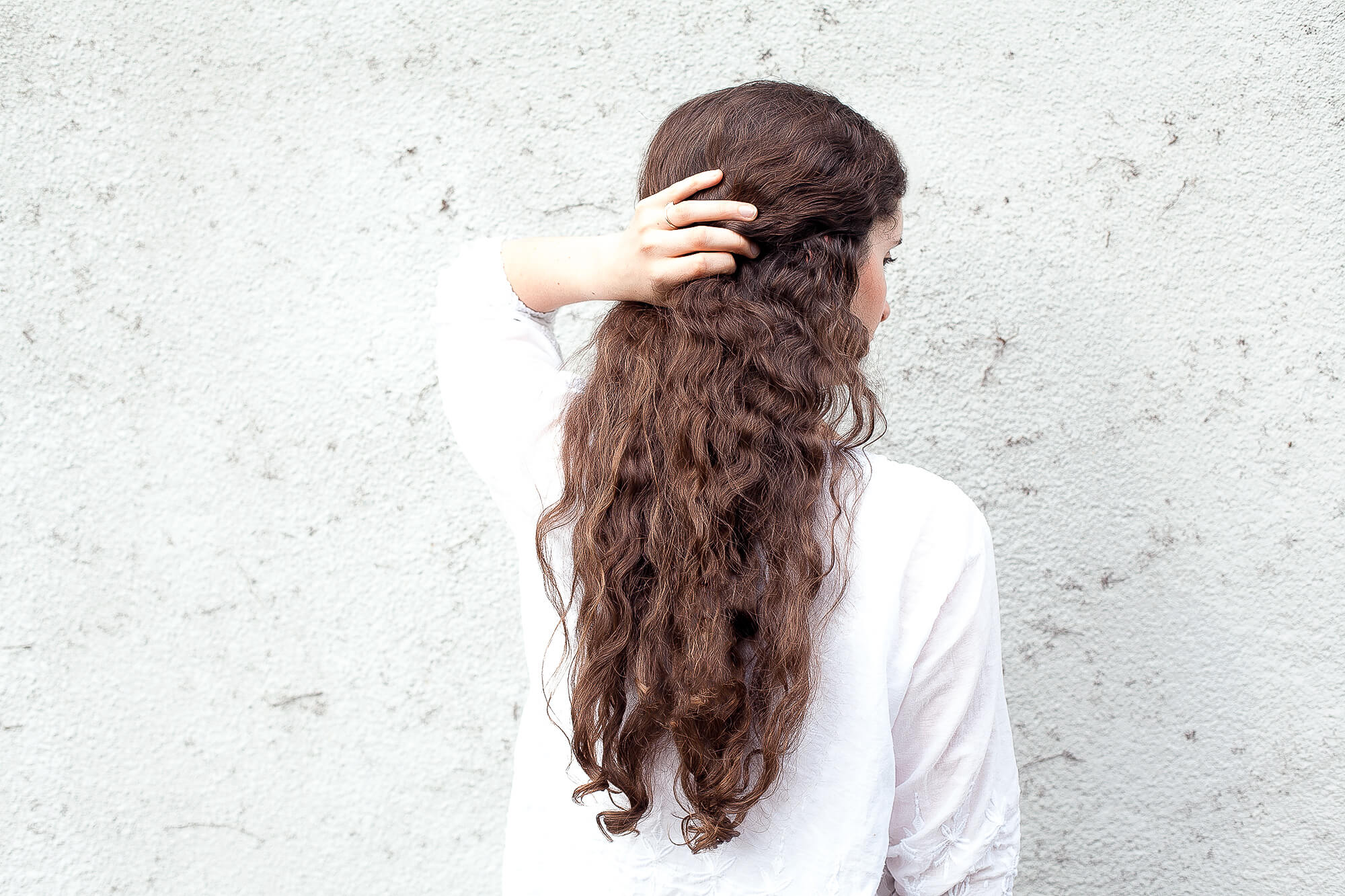 woman facing backwards with long dark curly hair