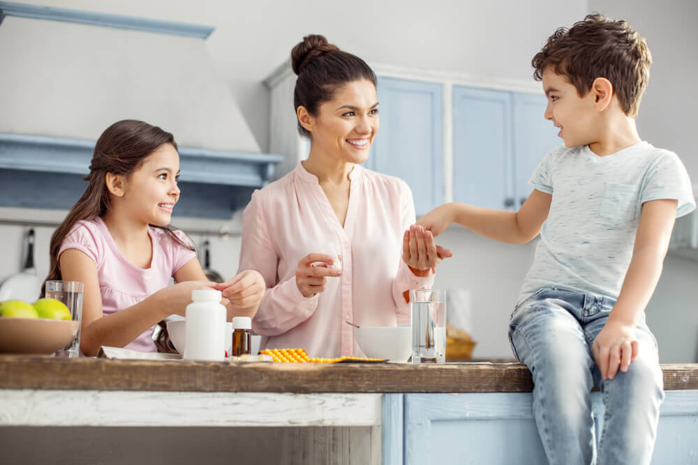 mom giving kids vitamins