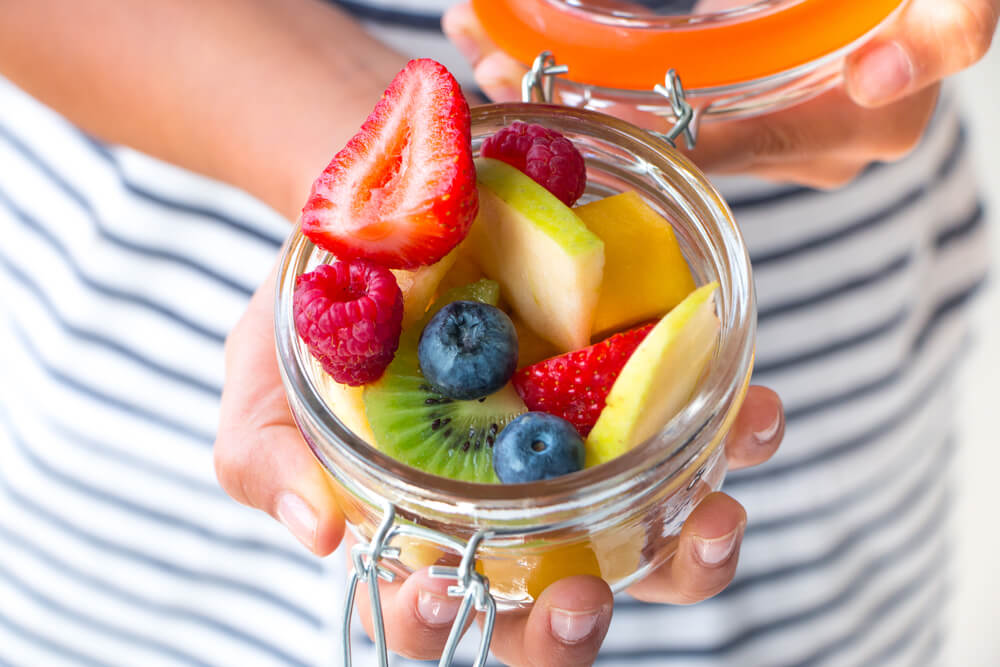 woman hold jar of fresh fruit as snack