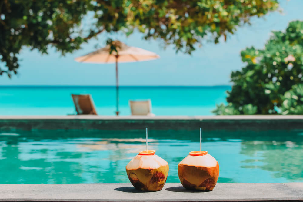 two coconut drinks poolside