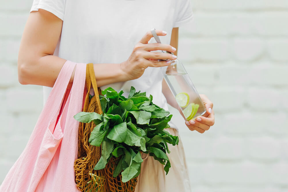 woman holding reusable bag and produce
