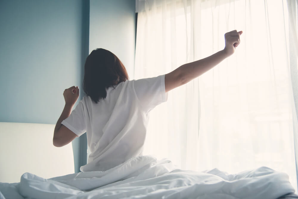 woman stretching as she gets out of bed