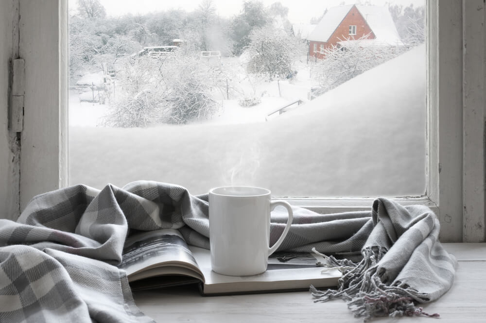 grey scarf and white mug by a winter window