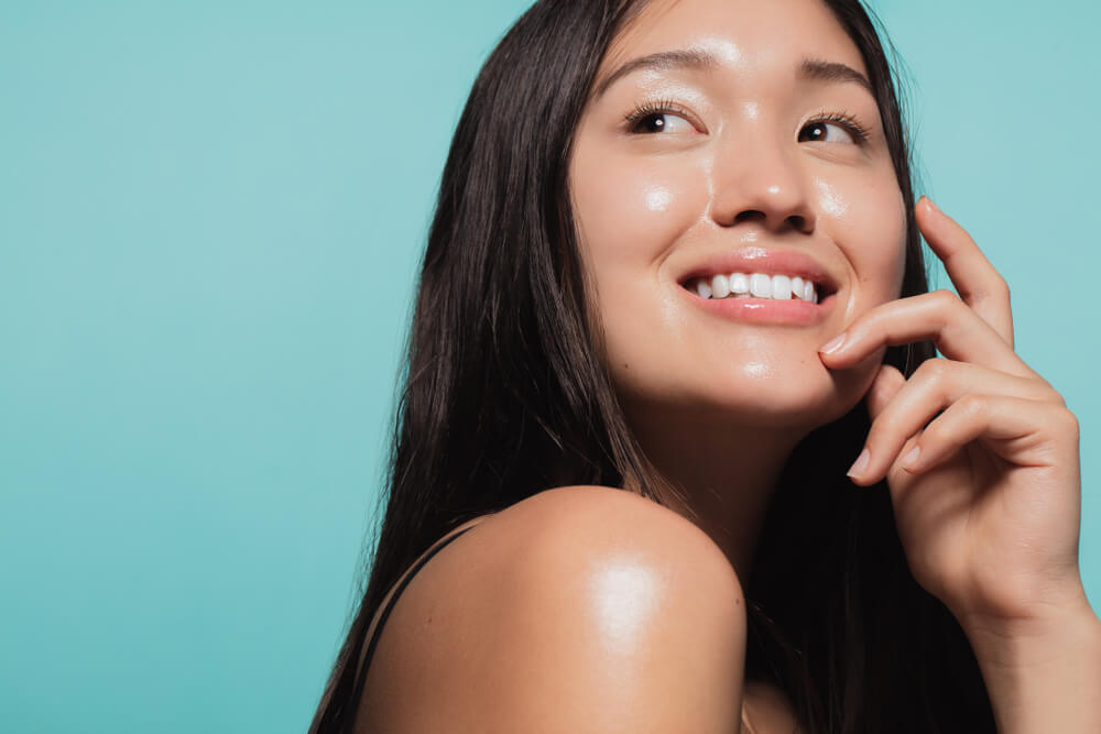 young woman with glowing skin on blue background