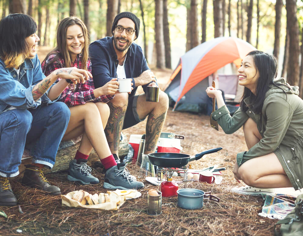 group of friends cooking while camping