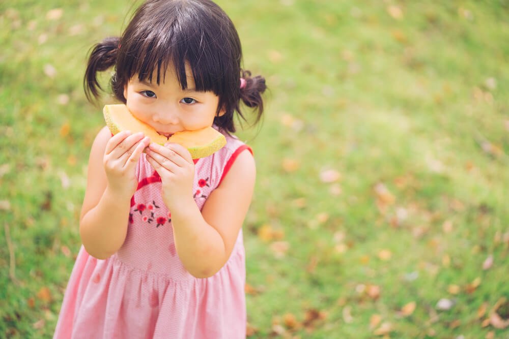 young Asian Girl eater fruit