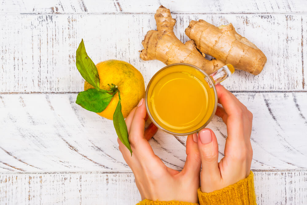 woman's hand holding a lemon ginger tea