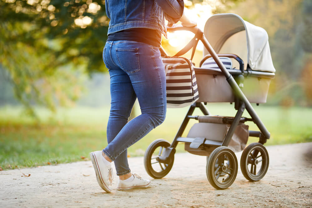 Mom walking with Baby in stroller in the spring time
