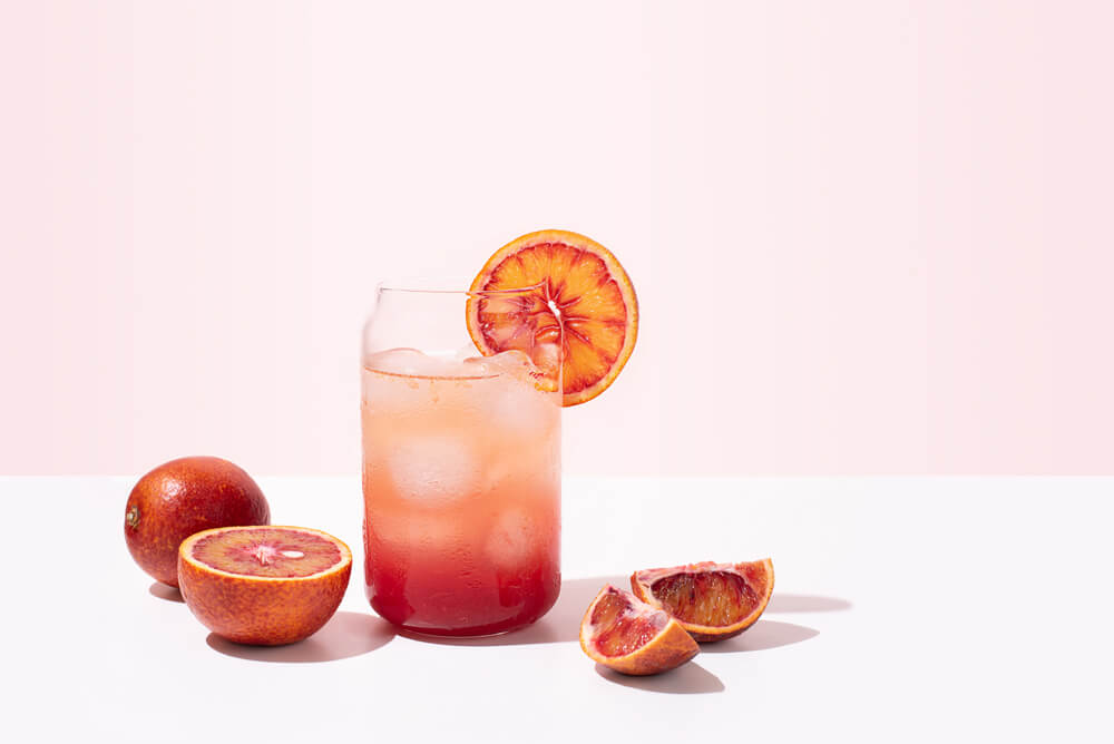 colourful beverage with slices of blood orange around it