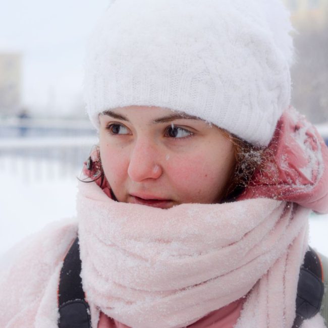 woman in white toque and pink scarf