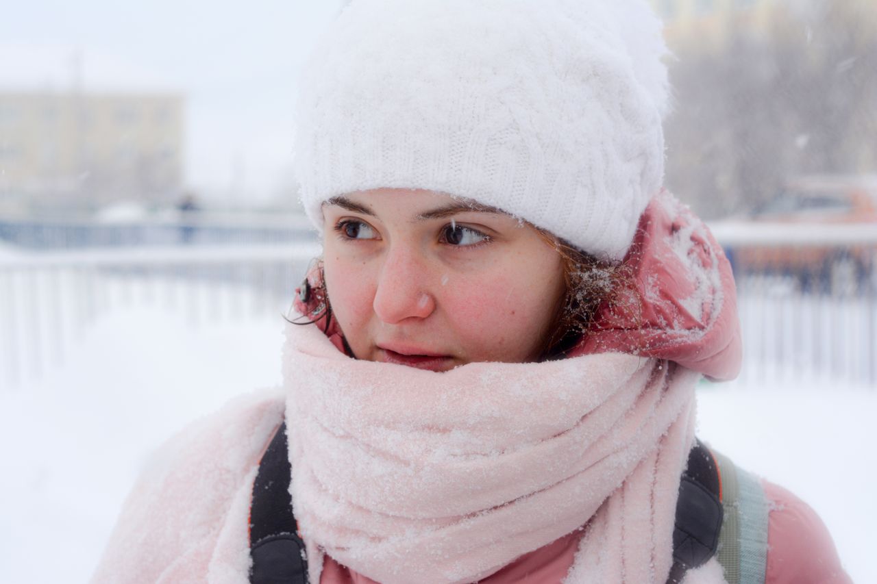 woman in white toque and pink scarf